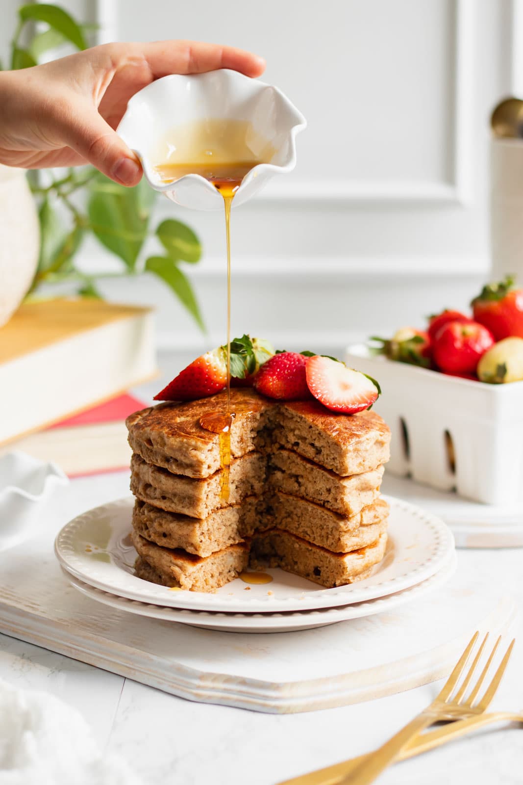 fluffy vegan banana oat pancakes with maple syrup being poured